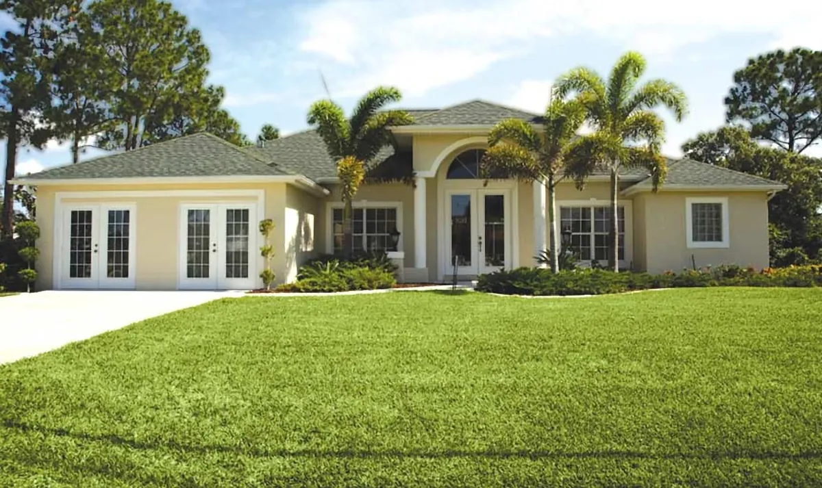 Florida home with palms and a full green lawn