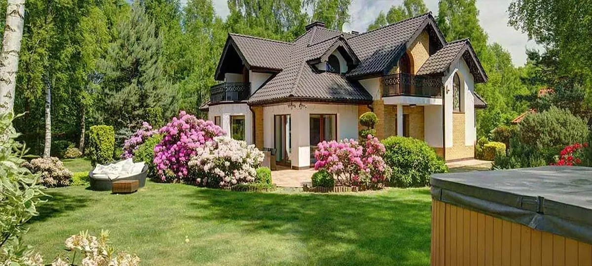 Home with flowering azaleas, trimmed shrubs and a green lawn